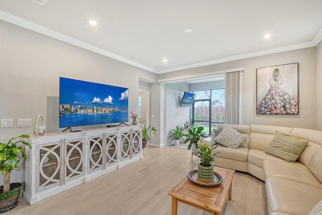 living room with ornamental molding and light hardwood / wood-style floors