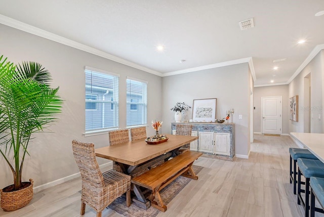 dining area featuring crown molding and light wood-type flooring