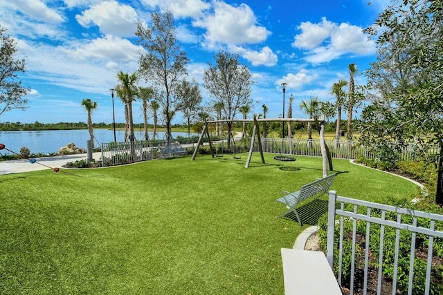 surrounding community with a water view, a lawn, and a playground