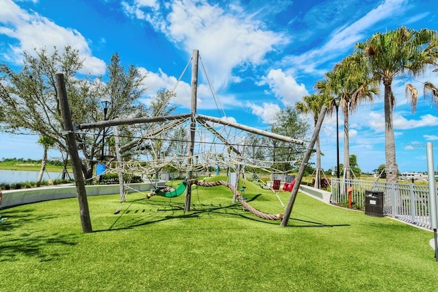 view of jungle gym with central AC, a yard, and a water view