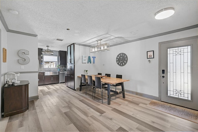 6738 Brentford Rd, Sarasota, FL 34241 - dining area with a textured ceiling, light wood-style flooring, a chandelier, and crown molding