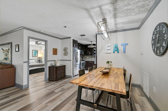 6738 Brentford Rd, Sarasota, FL 34241 - dining area featuring crown molding, light wood-type flooring, ceiling fan, and a textured ceiling