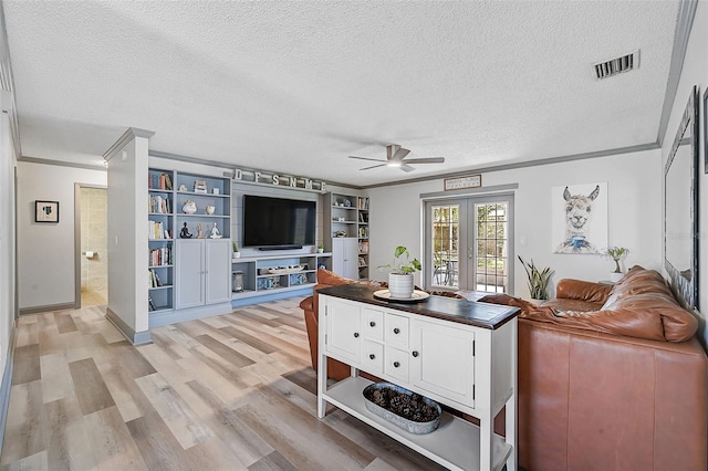 living room featuring light hardwood / wood-style floors, french doors, and a textured ceiling