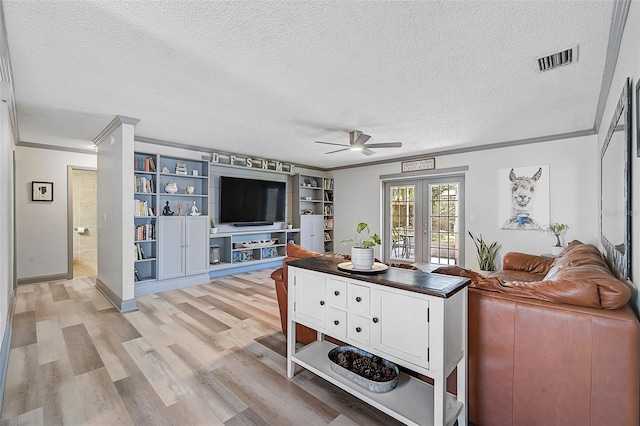 6738 Brentford Rd, Sarasota, FL 34241 - living room featuring crown molding, ceiling fan, a textured ceiling, and light wood-style flooring