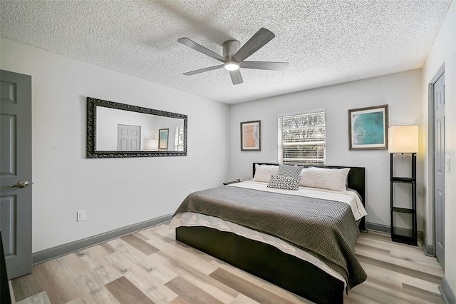 bedroom featuring a textured ceiling, light wood-type flooring, and ceiling fan