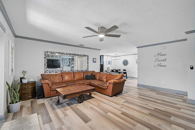 6738 Brentford Rd, Sarasota, FL 34241 - living room featuring ceiling fan, light wood-style flooring, a textured ceiling, and crown molding