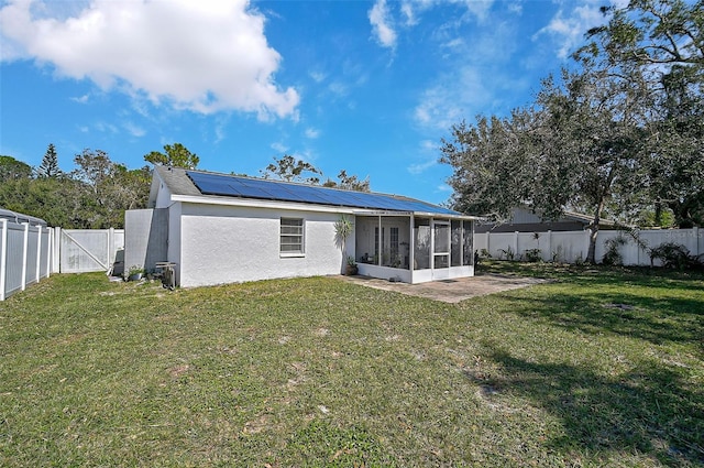 6738 Brentford Rd, Sarasota, FL 34241 - back of house with a sunroom, solar panels, a fenced backyard, and stucco siding