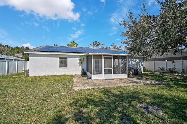 6738 Brentford Rd, Sarasota, FL 34241 - rear view of property with a sunroom, solar panels, a patio, and a fenced backyard