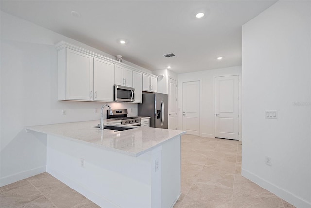 kitchen with sink, kitchen peninsula, white cabinetry, stainless steel appliances, and light stone counters