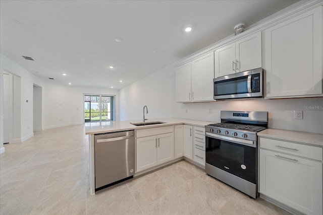 kitchen with sink, white cabinetry, kitchen peninsula, and stainless steel appliances