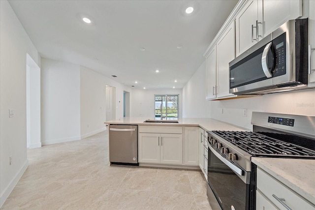 kitchen with kitchen peninsula, white cabinetry, stainless steel appliances, and sink