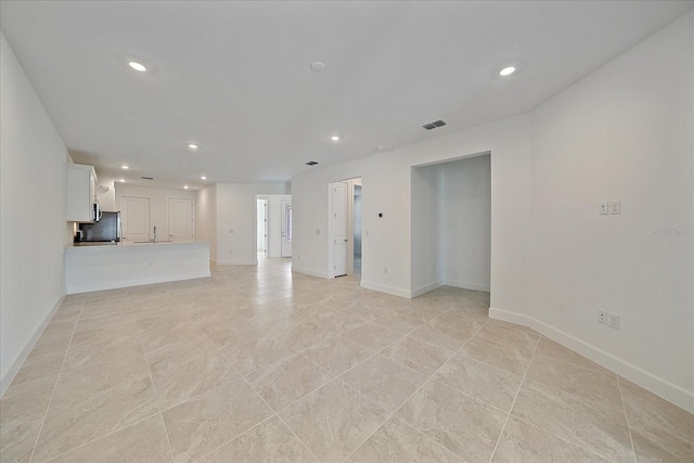 unfurnished living room featuring sink