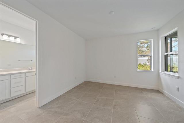 unfurnished room with sink and light tile patterned floors