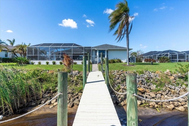 view of dock with a lanai and a yard