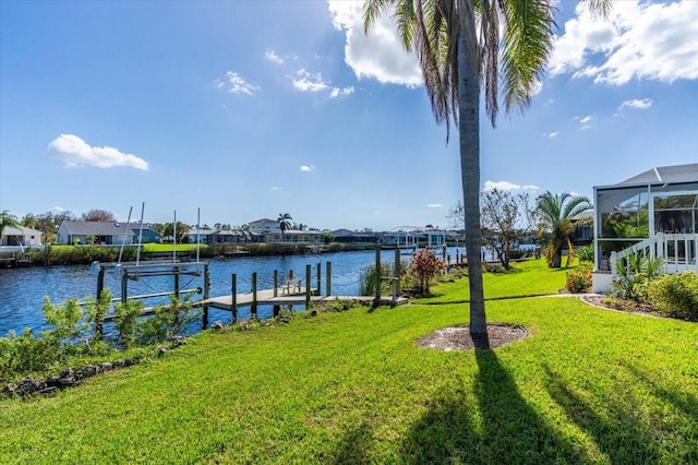 dock area with a yard, a water view, and a lanai