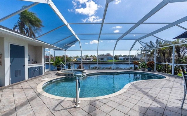 view of swimming pool with glass enclosure, a patio area, an in ground hot tub, and a water view