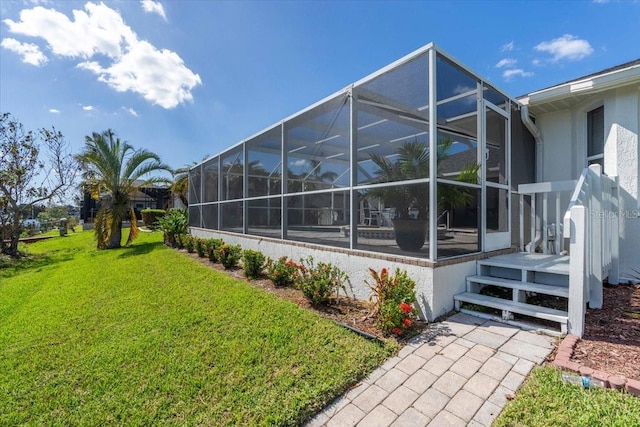 view of side of home with glass enclosure and a lawn