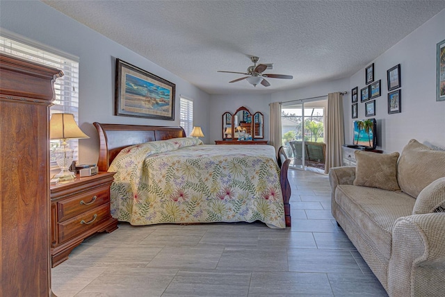 bedroom with a textured ceiling, access to exterior, and ceiling fan