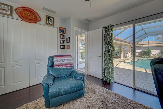 sitting room with dark wood-type flooring, a textured ceiling, and a wealth of natural light