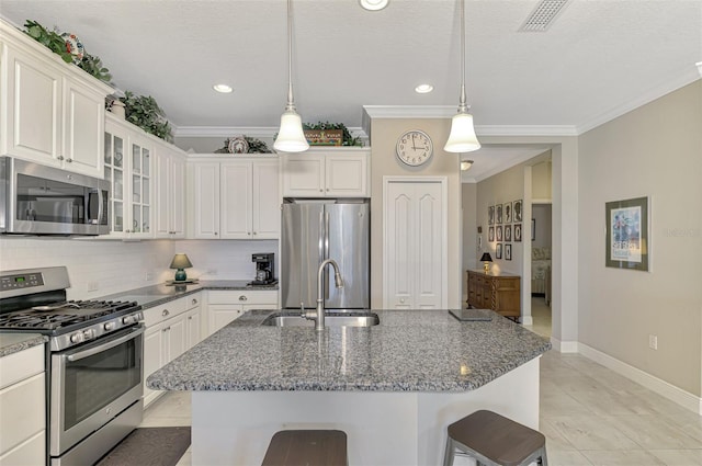 kitchen with crown molding, hanging light fixtures, stainless steel appliances, and dark stone counters