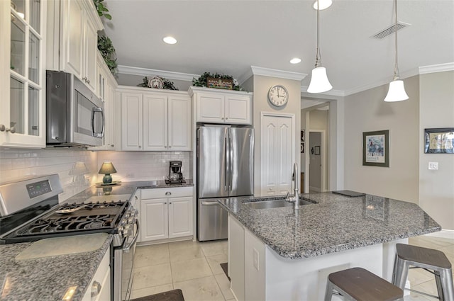 kitchen featuring sink, stainless steel appliances, dark stone counters, decorative light fixtures, and ornamental molding