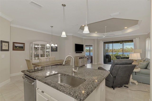 kitchen featuring dishwasher, an island with sink, sink, pendant lighting, and white cabinets