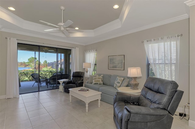 living room featuring crown molding, a raised ceiling, light tile patterned floors, and ceiling fan