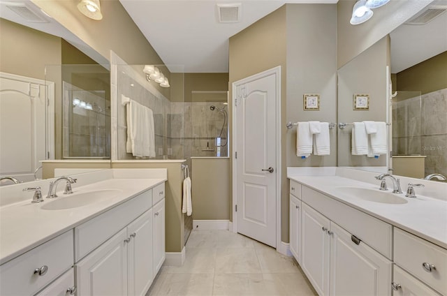 bathroom with a tile shower, tile patterned flooring, and vanity