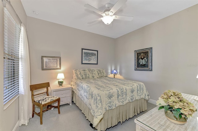 bedroom with ceiling fan, light carpet, and multiple windows