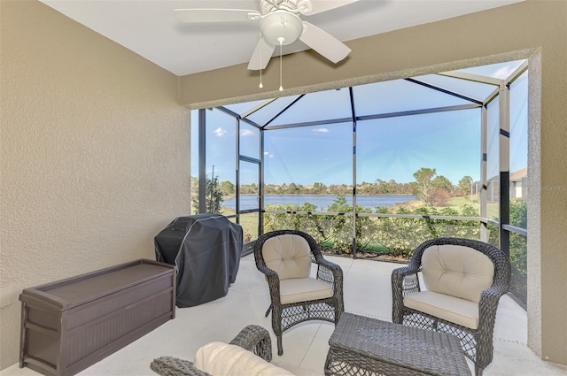 sunroom featuring a water view and ceiling fan