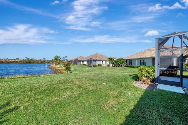 view of yard featuring a water view and glass enclosure