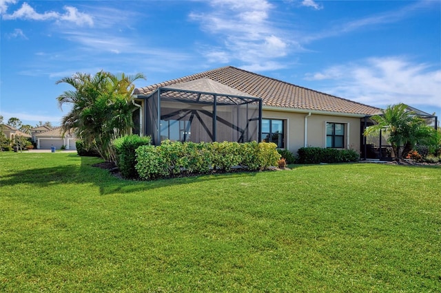 exterior space featuring glass enclosure and a lawn