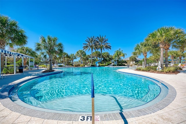 view of swimming pool featuring a water slide and a patio area