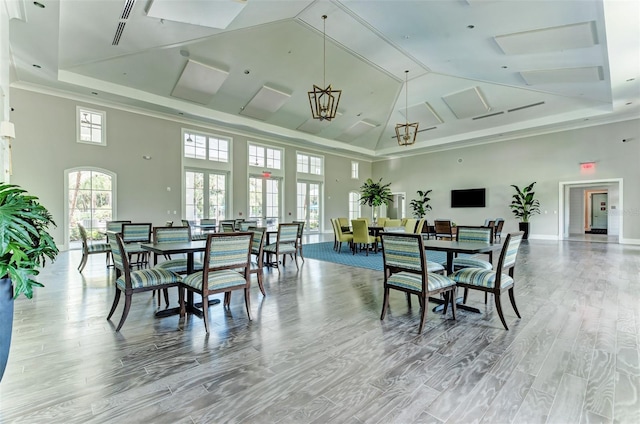 dining area with hardwood / wood-style flooring and a high ceiling