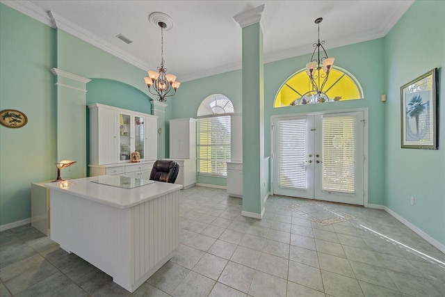 interior space with french doors, a high ceiling, ornate columns, ornamental molding, and light tile patterned floors