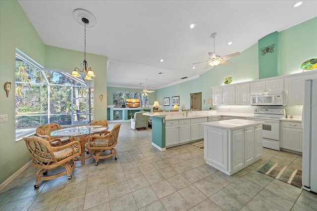 kitchen featuring white appliances, a center island, ceiling fan with notable chandelier, and white cabinets