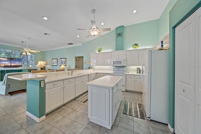 kitchen featuring white appliances, sink, a center island, kitchen peninsula, and white cabinetry