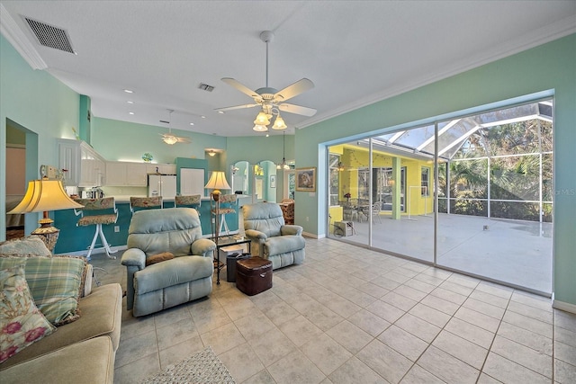 living room with crown molding, ceiling fan, and light tile patterned floors