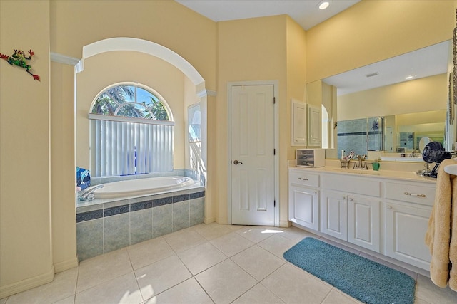 bathroom with vanity, tiled tub, and tile patterned flooring