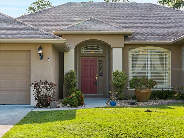 property entrance featuring a garage and a lawn