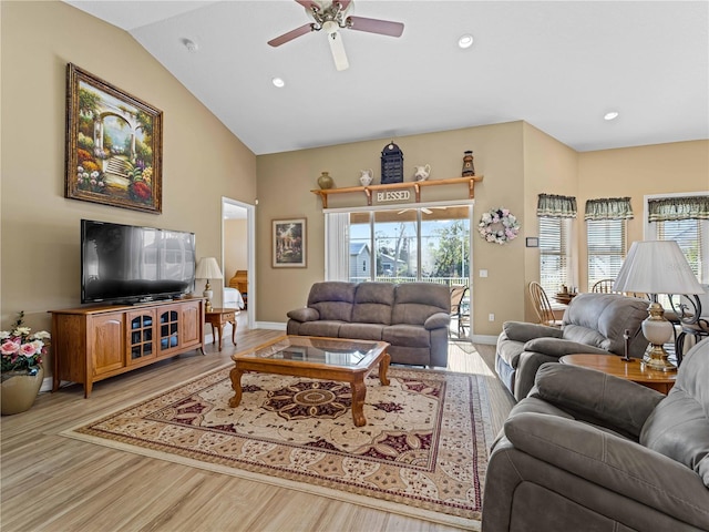 living room featuring light hardwood / wood-style floors, vaulted ceiling, and ceiling fan