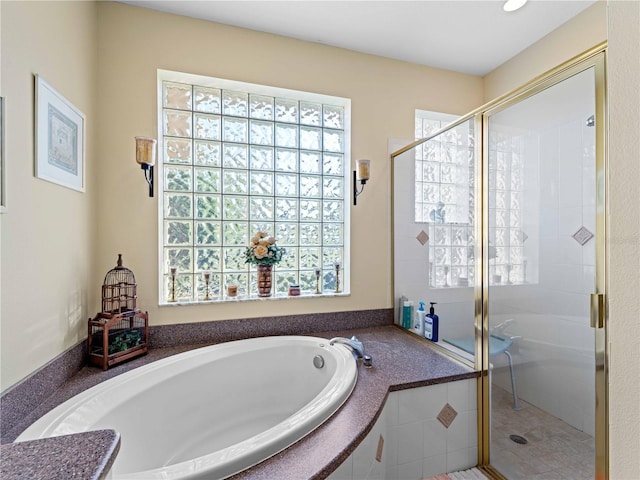 bathroom with independent shower and bath and tile patterned flooring