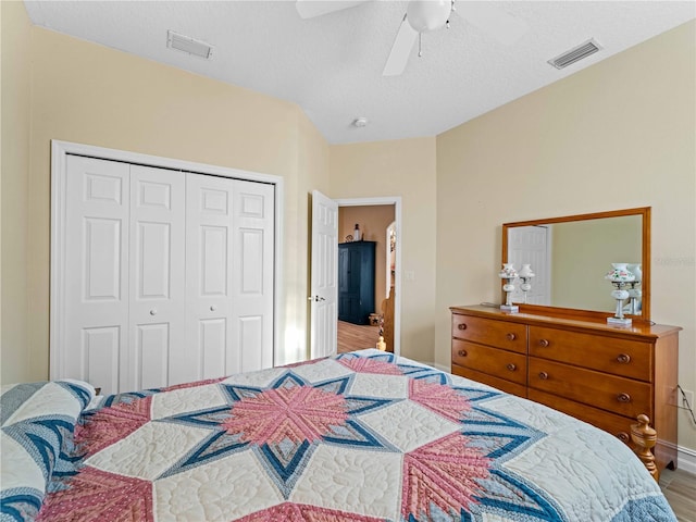 bedroom with a textured ceiling, hardwood / wood-style flooring, a closet, and ceiling fan