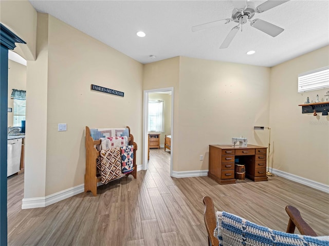 living area featuring light wood-type flooring and ceiling fan