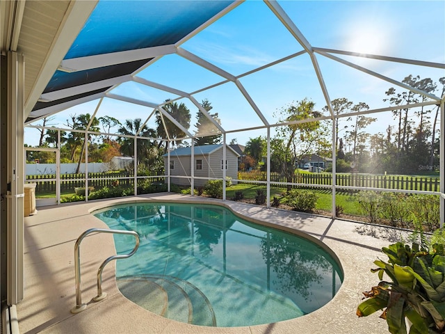 view of swimming pool with a patio area, a lanai, and a shed