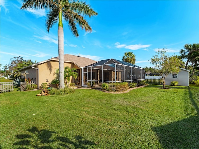 rear view of property with a lanai and a yard