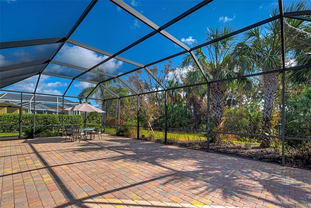 view of patio featuring glass enclosure