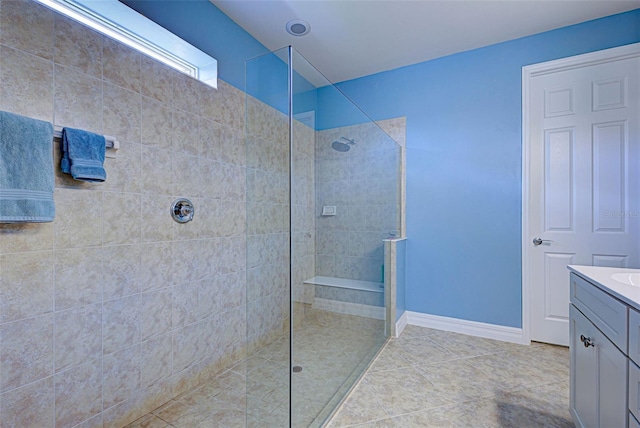 bathroom with vanity, tiled shower, and tile patterned flooring