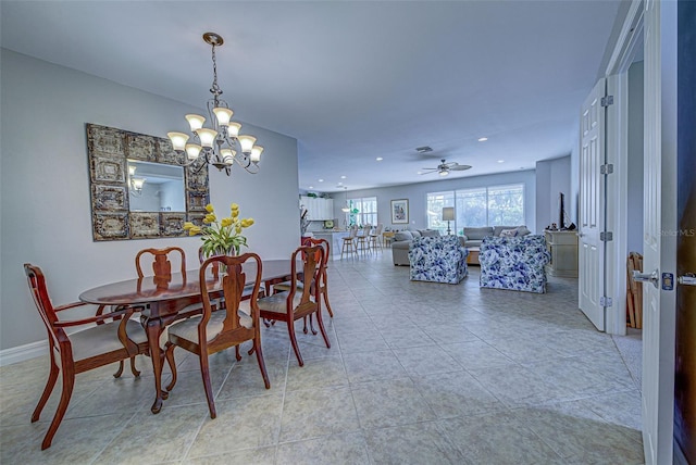 tiled dining room with ceiling fan with notable chandelier