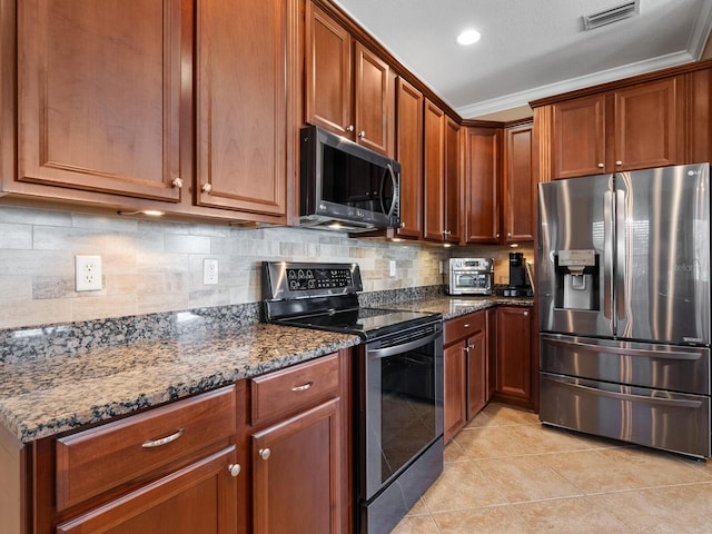 kitchen featuring light tile patterned floors, appliances with stainless steel finishes, ornamental molding, decorative backsplash, and dark stone counters